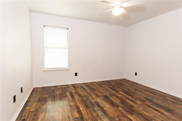 empty room featuring baseboards, dark wood-style flooring, and ceiling fan