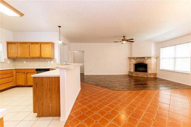 kitchen featuring a peninsula, light tile patterned flooring, light countertops, and backsplash