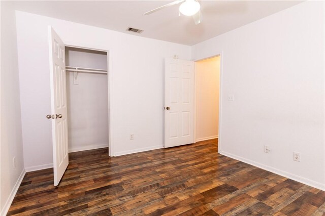 unfurnished bedroom with visible vents, baseboards, a closet, and dark wood finished floors