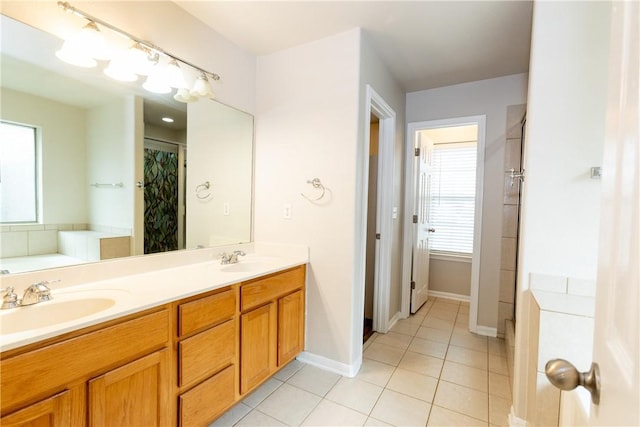 bathroom featuring a sink, a bathing tub, double vanity, and tile patterned flooring