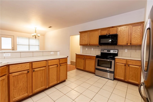 kitchen with tasteful backsplash, appliances with stainless steel finishes, brown cabinetry, and light countertops