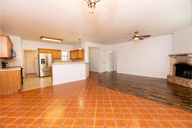 unfurnished living room featuring light tile patterned floors, a fireplace, and a ceiling fan