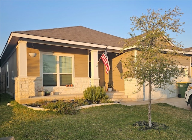 view of front of home featuring a porch, a garage, and a front yard