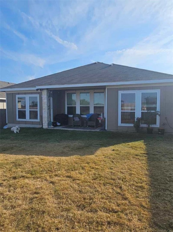 rear view of house with a yard and a patio