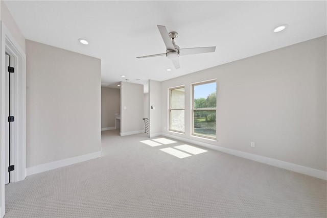 empty room featuring ceiling fan and light colored carpet