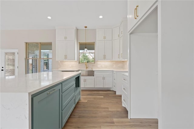 kitchen featuring light wood-type flooring, white cabinetry, pendant lighting, and plenty of natural light