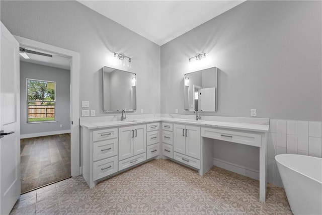 bathroom with a tub, vanity, ceiling fan, and tile patterned flooring