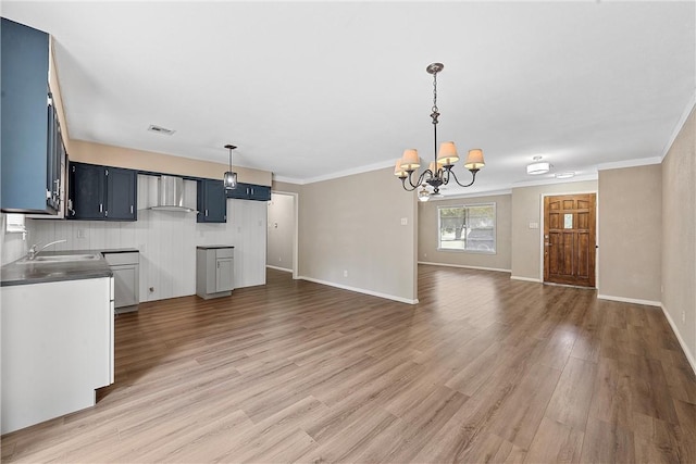 kitchen featuring blue cabinets, crown molding, sink, a notable chandelier, and wood-type flooring