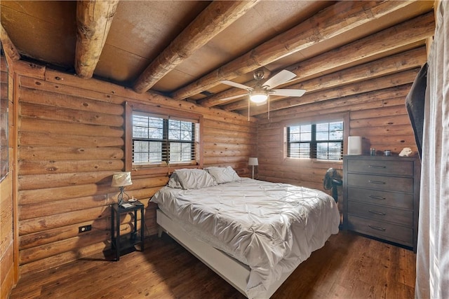 bedroom featuring multiple windows, beam ceiling, and dark wood-type flooring