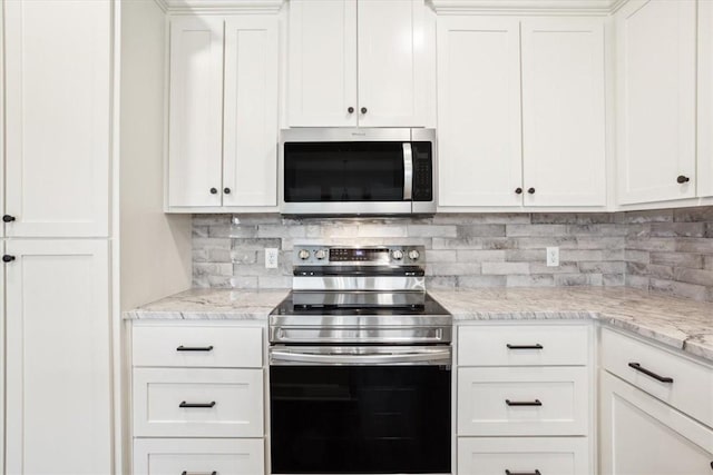 kitchen with white cabinets, appliances with stainless steel finishes, decorative backsplash, and light stone counters