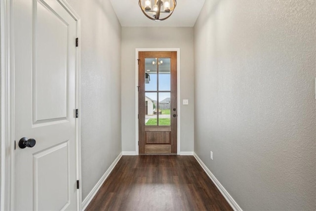 doorway to outside featuring a chandelier and dark wood-type flooring