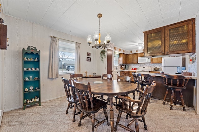 carpeted dining room with an inviting chandelier