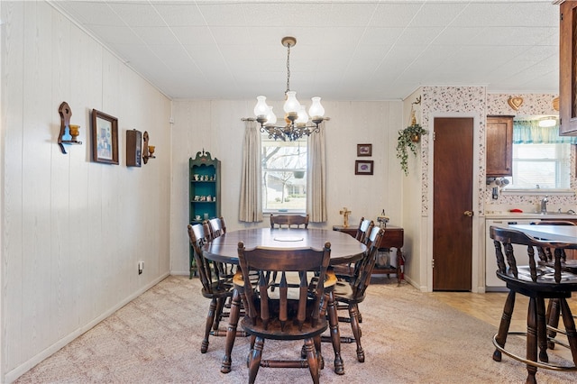 dining space with a chandelier and light carpet