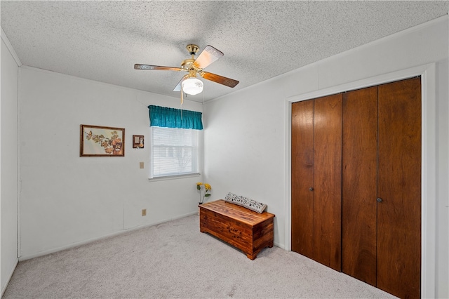 bedroom featuring light colored carpet, a textured ceiling, and a closet