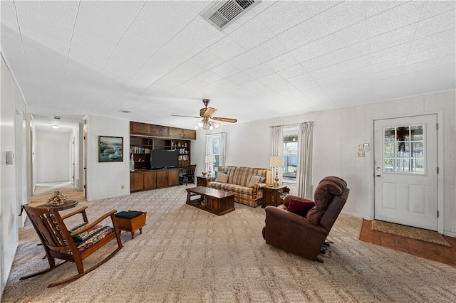 carpeted living room featuring ceiling fan