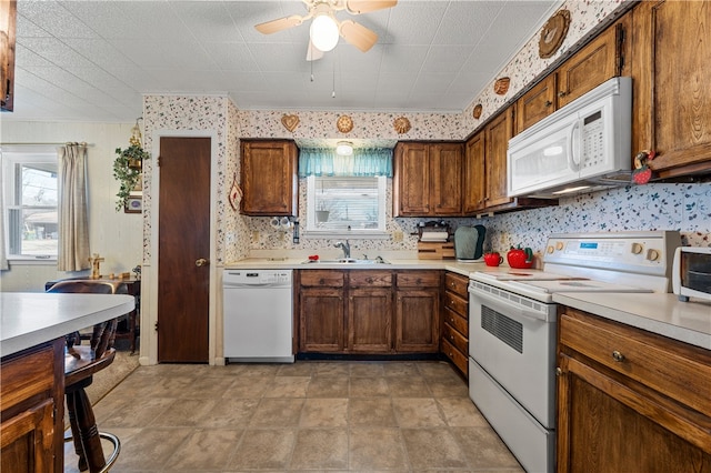 kitchen featuring ceiling fan, white appliances, sink, and decorative backsplash