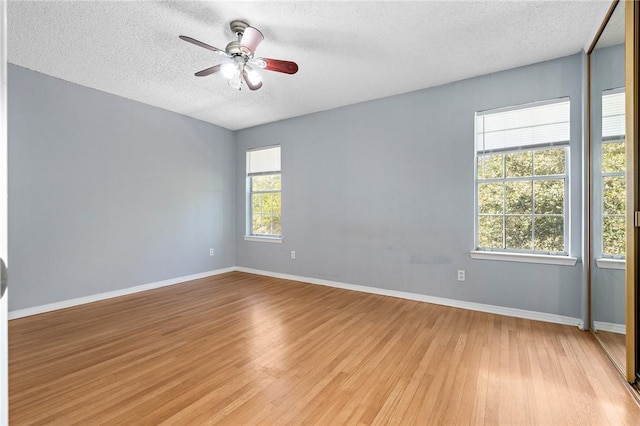 spare room with a textured ceiling, light hardwood / wood-style flooring, and ceiling fan