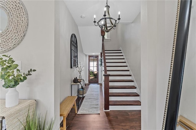 entryway featuring dark hardwood / wood-style floors, a notable chandelier, and a towering ceiling