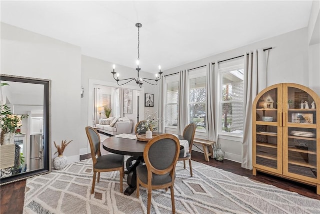 dining room with dark hardwood / wood-style flooring and a notable chandelier