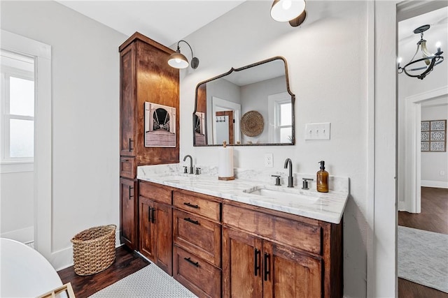 bathroom with vanity, wood-type flooring, and an inviting chandelier