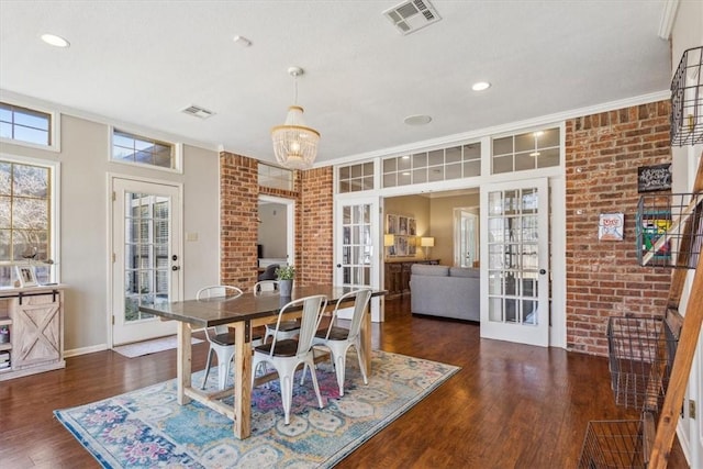 dining area with visible vents, dark wood finished floors, brick wall, crown molding, and french doors