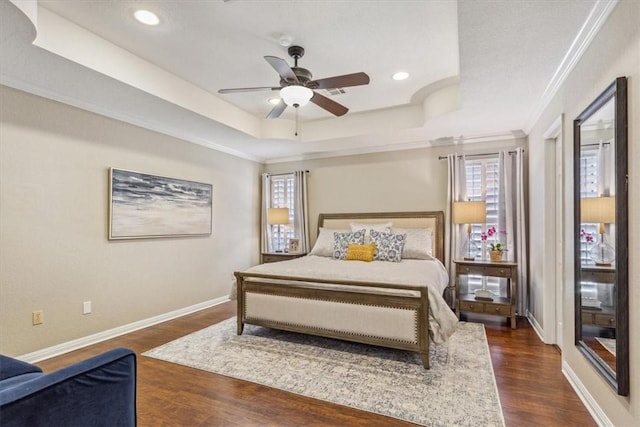 bedroom featuring baseboards, dark wood-style floors, a tray ceiling, crown molding, and recessed lighting