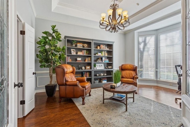 sitting room featuring crown molding, a tray ceiling, a chandelier, and wood finished floors