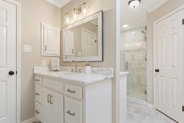 bathroom featuring baseboards, crown molding, a shower stall, and vanity