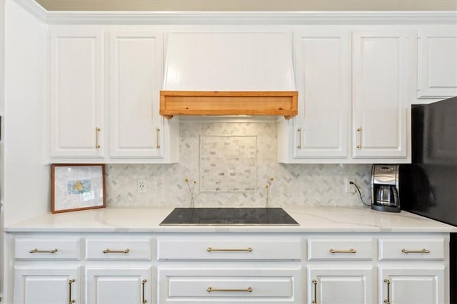 kitchen featuring tasteful backsplash, white cabinets, premium range hood, and black appliances