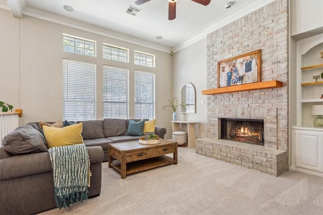 living area featuring visible vents, crown molding, carpet flooring, built in shelves, and a fireplace