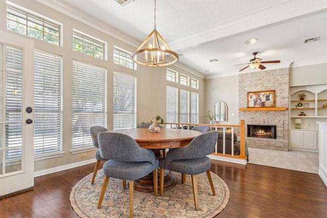 dining space featuring ornamental molding, wood-type flooring, and a brick fireplace