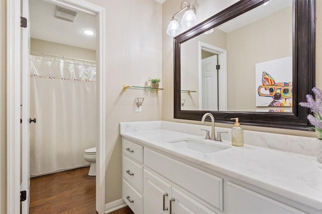 full bath featuring toilet, visible vents, wood finished floors, and vanity