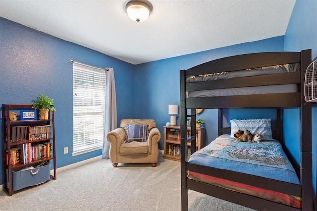 bedroom featuring a textured wall, carpet flooring, and baseboards