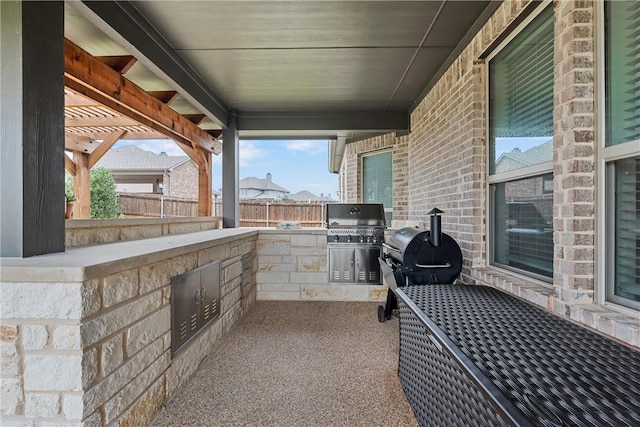 view of patio / terrace featuring a pergola, grilling area, and exterior kitchen