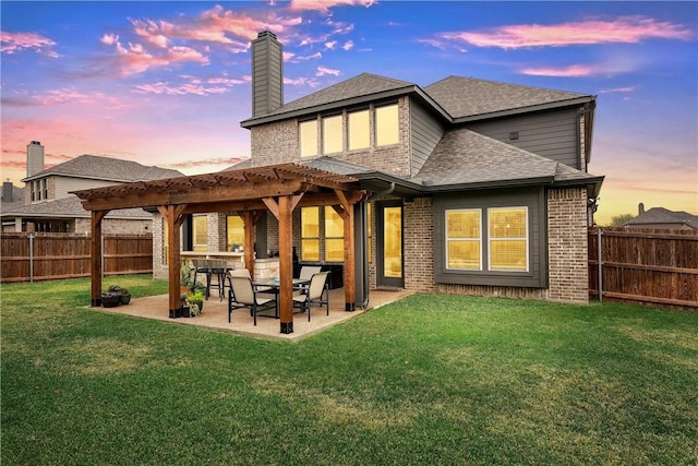 back house at dusk featuring a pergola, a lawn, and a patio