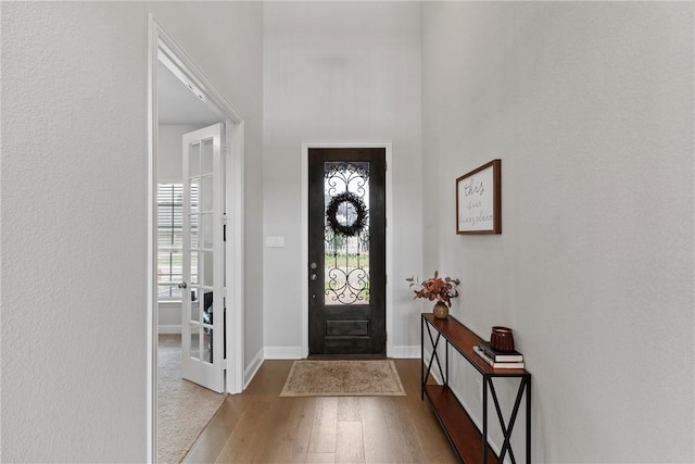 foyer featuring hardwood / wood-style floors, french doors, and a healthy amount of sunlight