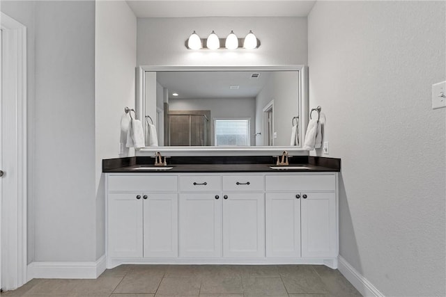 bathroom with tile patterned flooring, vanity, and a shower with shower door