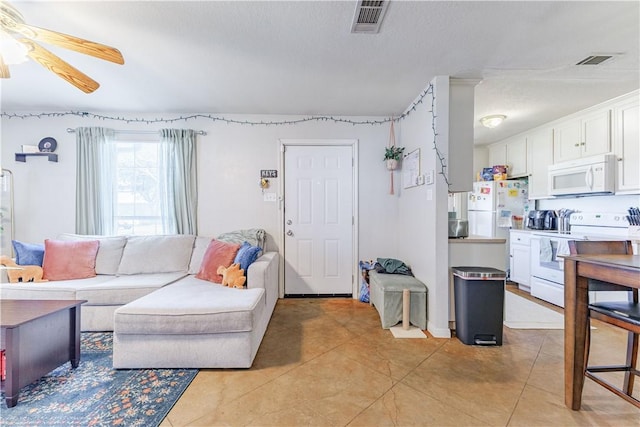 living room with light tile patterned floors, ceiling fan, and visible vents