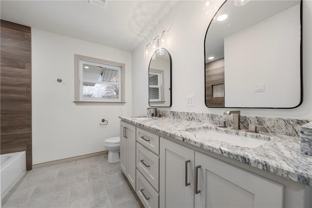 full bathroom featuring a sink, baseboards, toilet, and a washtub