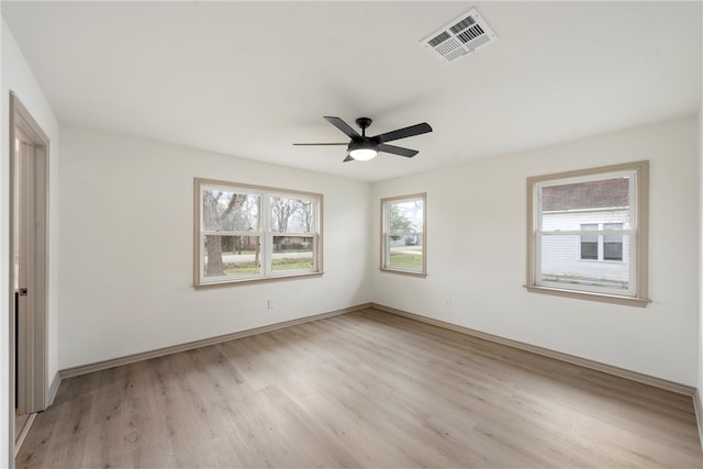 spare room with baseboards, a ceiling fan, visible vents, and light wood-type flooring