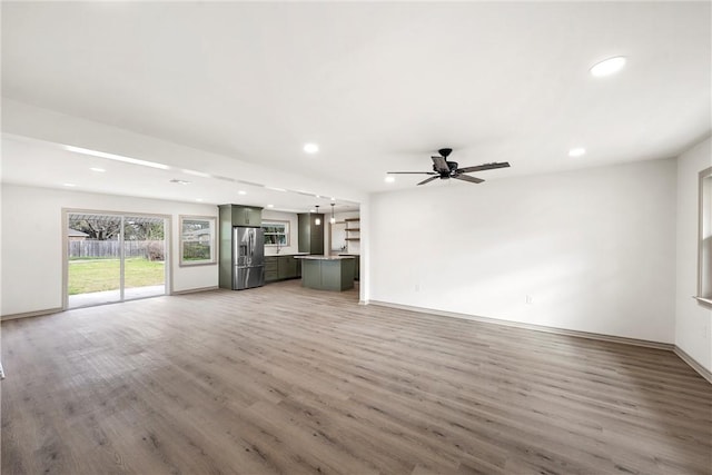 unfurnished living room featuring recessed lighting, baseboards, light wood-style floors, and ceiling fan