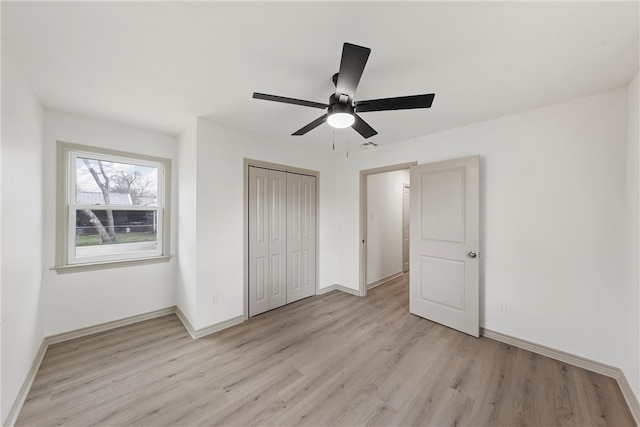 unfurnished bedroom with a closet, baseboards, light wood finished floors, and ceiling fan