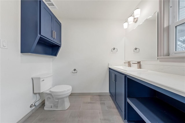 bathroom featuring vanity, toilet, baseboards, and visible vents