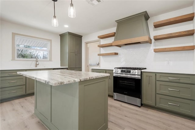 kitchen featuring visible vents, open shelves, premium range hood, stainless steel gas stove, and green cabinetry