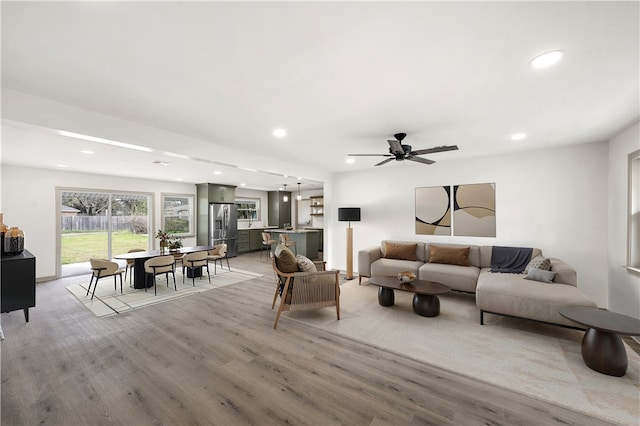 living area with a ceiling fan, recessed lighting, and light wood-type flooring