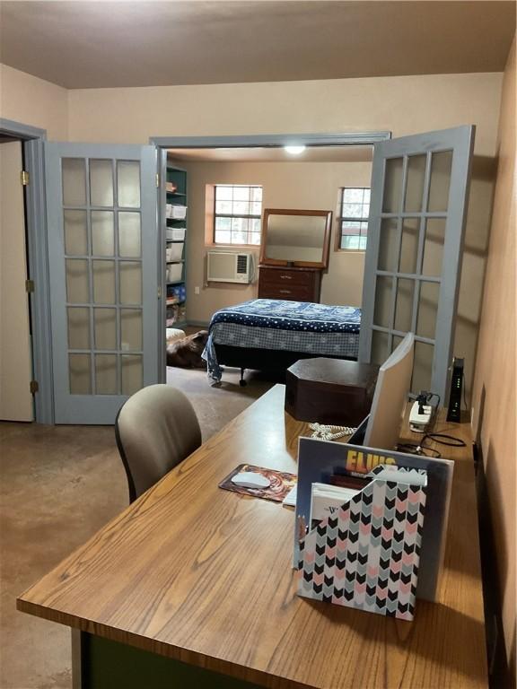 bedroom with cooling unit, concrete floors, and french doors