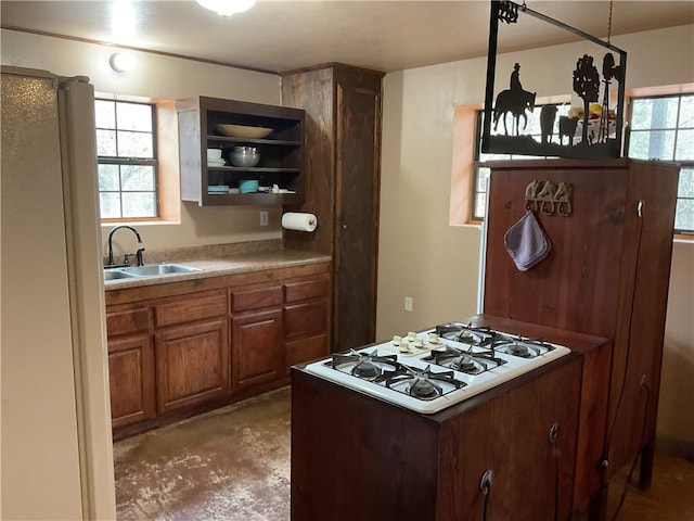 kitchen with concrete flooring, white appliances, a wealth of natural light, and sink