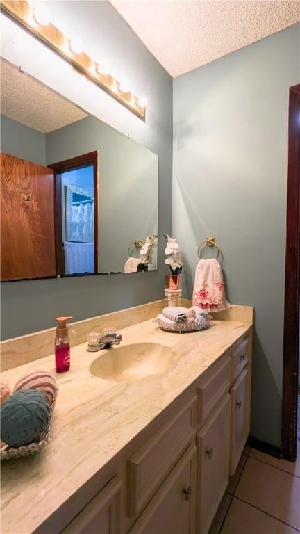 bathroom featuring tile patterned flooring, vanity, and a textured ceiling