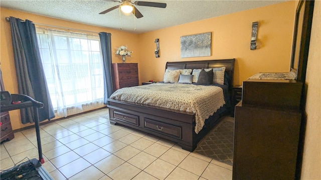 bedroom with ceiling fan, light tile patterned floors, and a textured ceiling