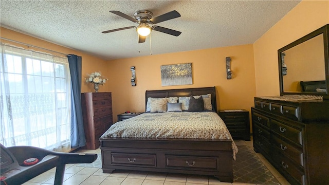 bedroom with ceiling fan, light tile patterned flooring, and a textured ceiling